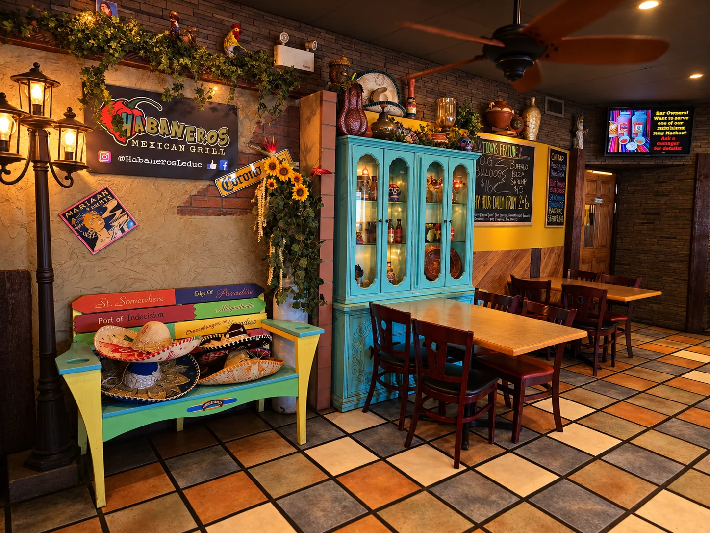 Colourful dining room at Habaneros Mexican Grill in downtown Leduc with sombreros, a painted bench and a turquoise cabinet